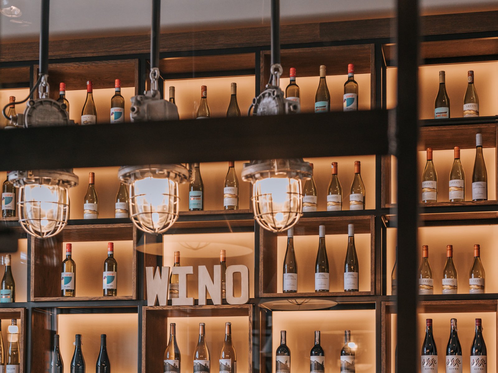 Sztolnia wine wall with large WINE sign and industrial cage lighting