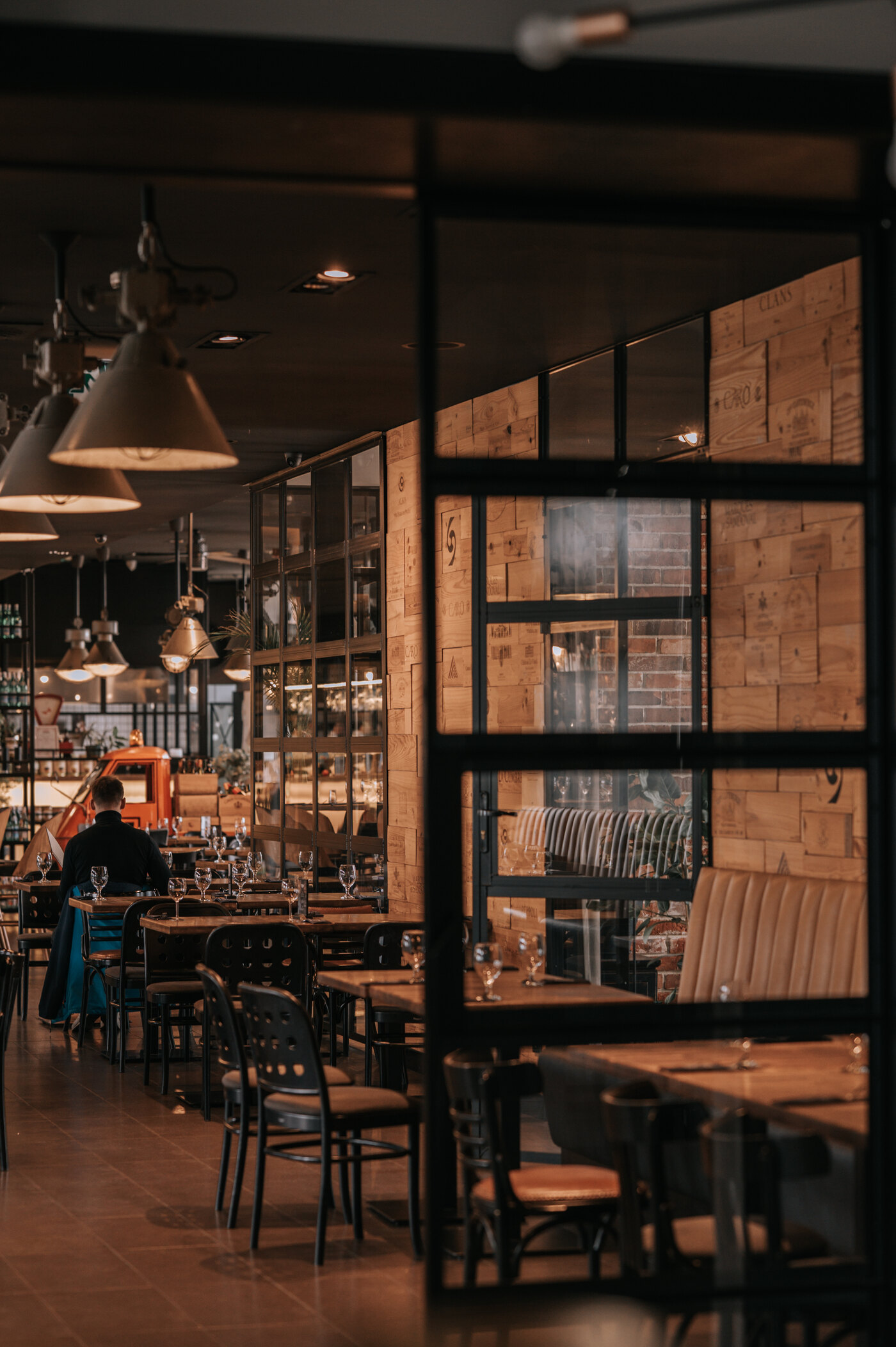 Busy Sztolnia dining room — glass wall framed in wooden wine crates, guests at tables